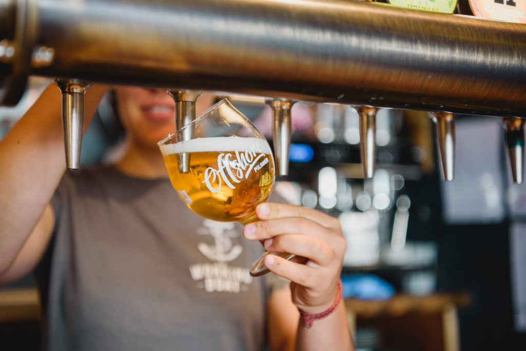 A bartender is pouring a glass of beer