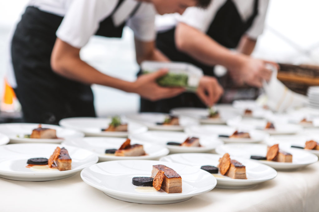 A table is filled with white plates, being dressed for service.
