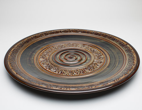 A large dark brown platter, with intricate patterns