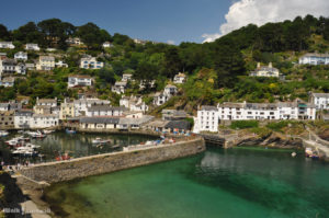 The village of Polperro. White houses on the cliffs overlooking the blue, green sea and the harbour.